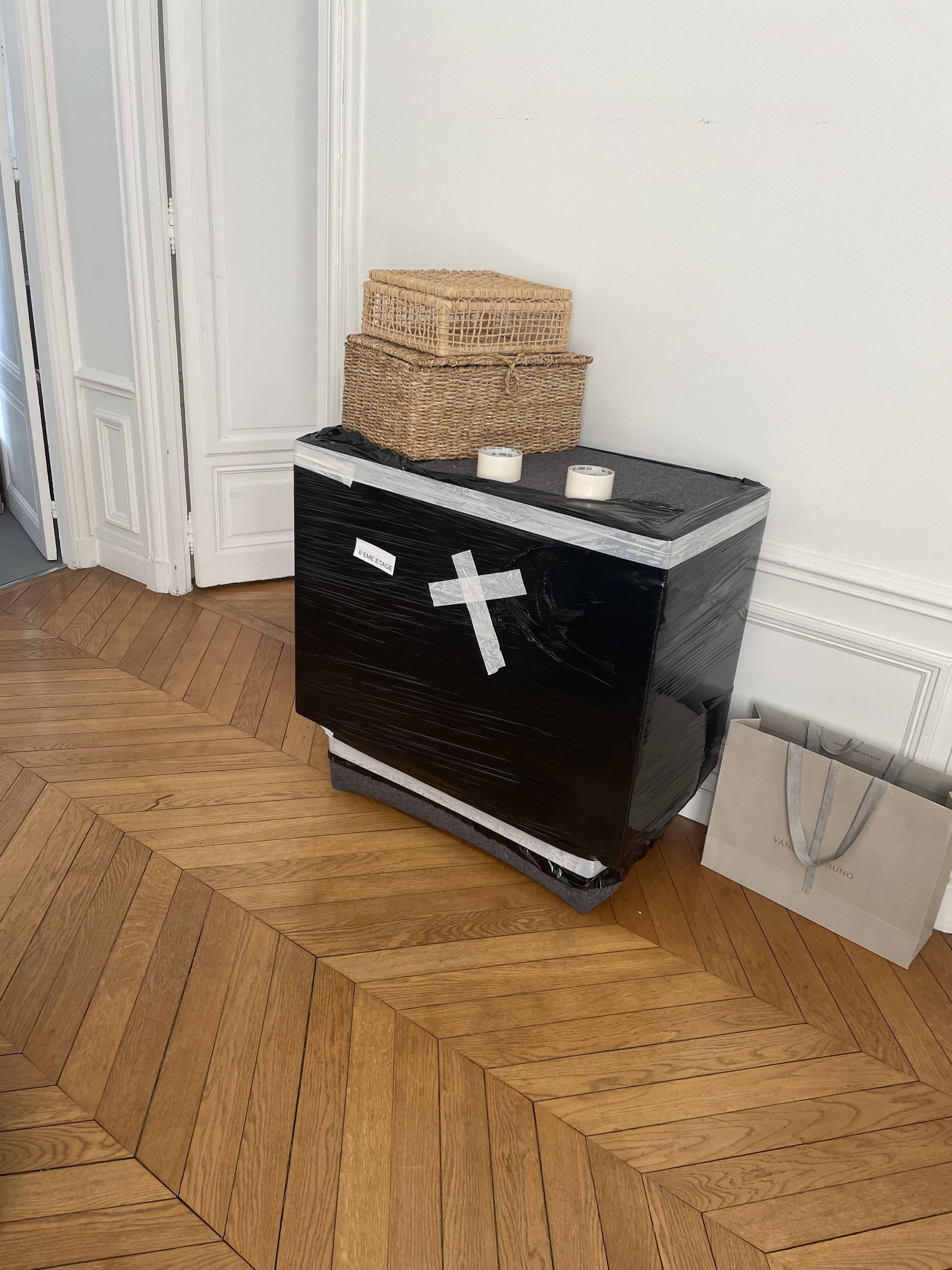 Meuble protégé et emballé sur parquet en chevrons